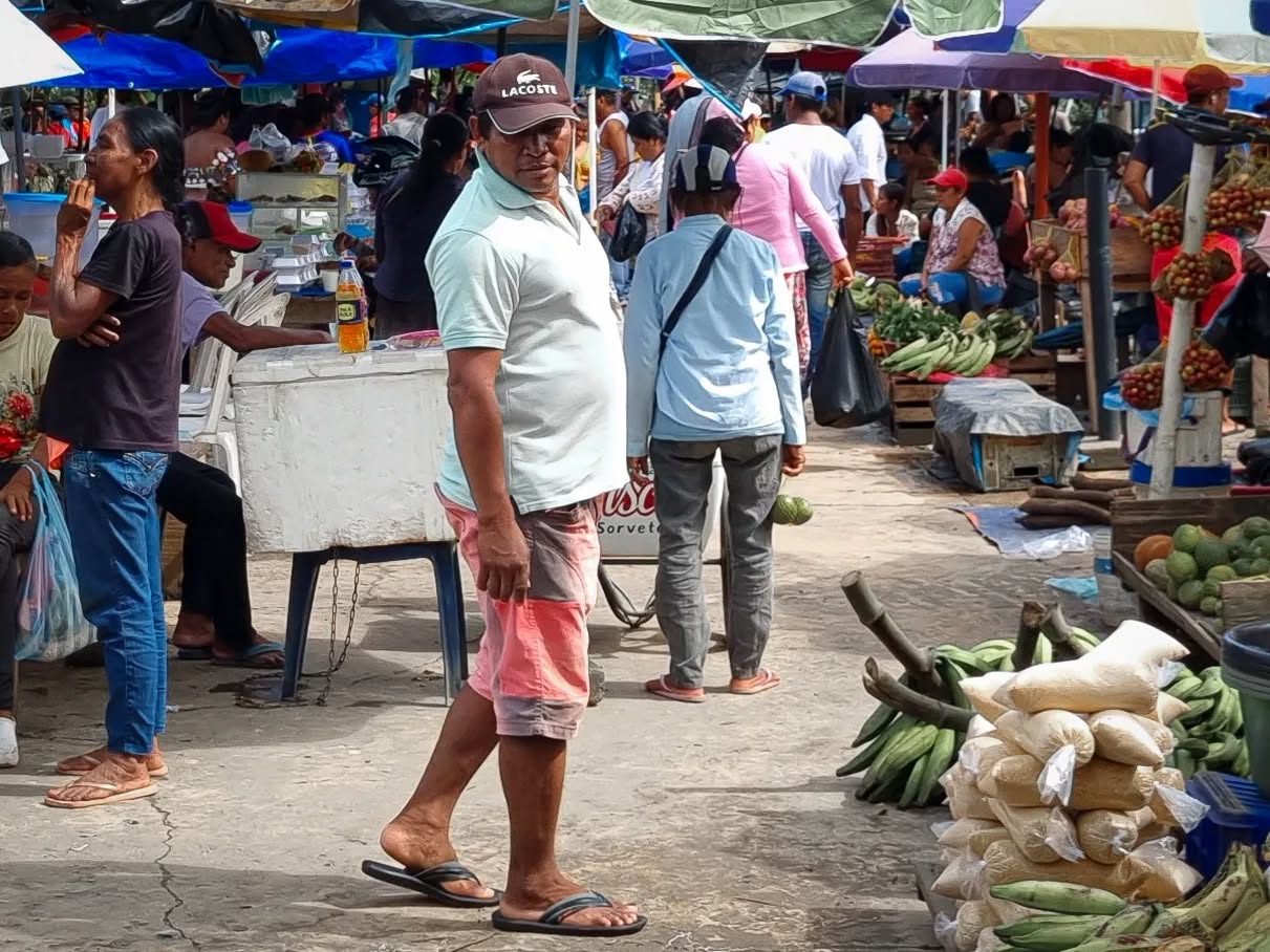 Mercado de Leticia con puestos de alimentos y personas recorriendo la plaza.